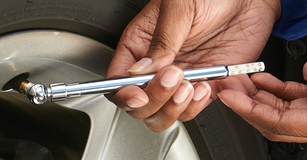 Checking a tire's air pressure by using a tire pressure gauge